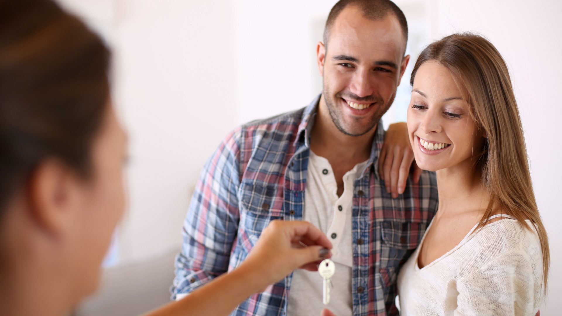 Cheerful couple getting keys of their new home